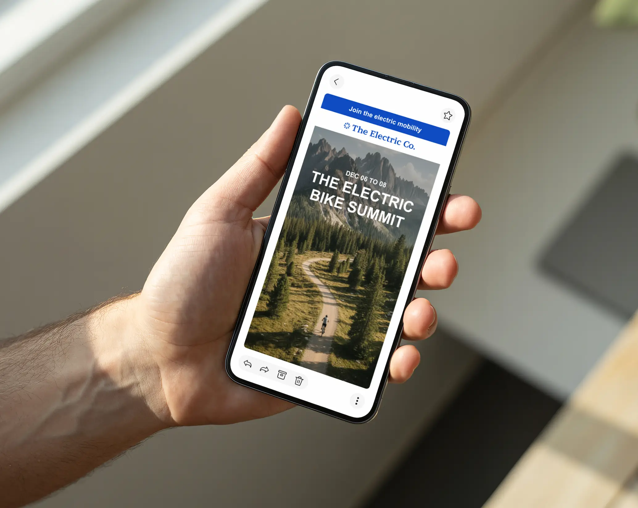 Une main tenant un téléphone montrant une newsletter