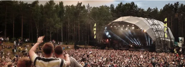 Image illustrant un évènement festif, avec un concert en plein air avec une foule enthousiaste.