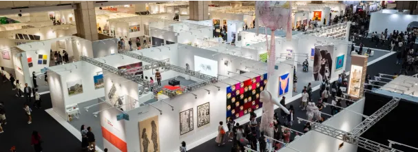 Image illustrant un évènement professionnel, avec la vue d'un salon d'exposition et divers stands et visiteurs.